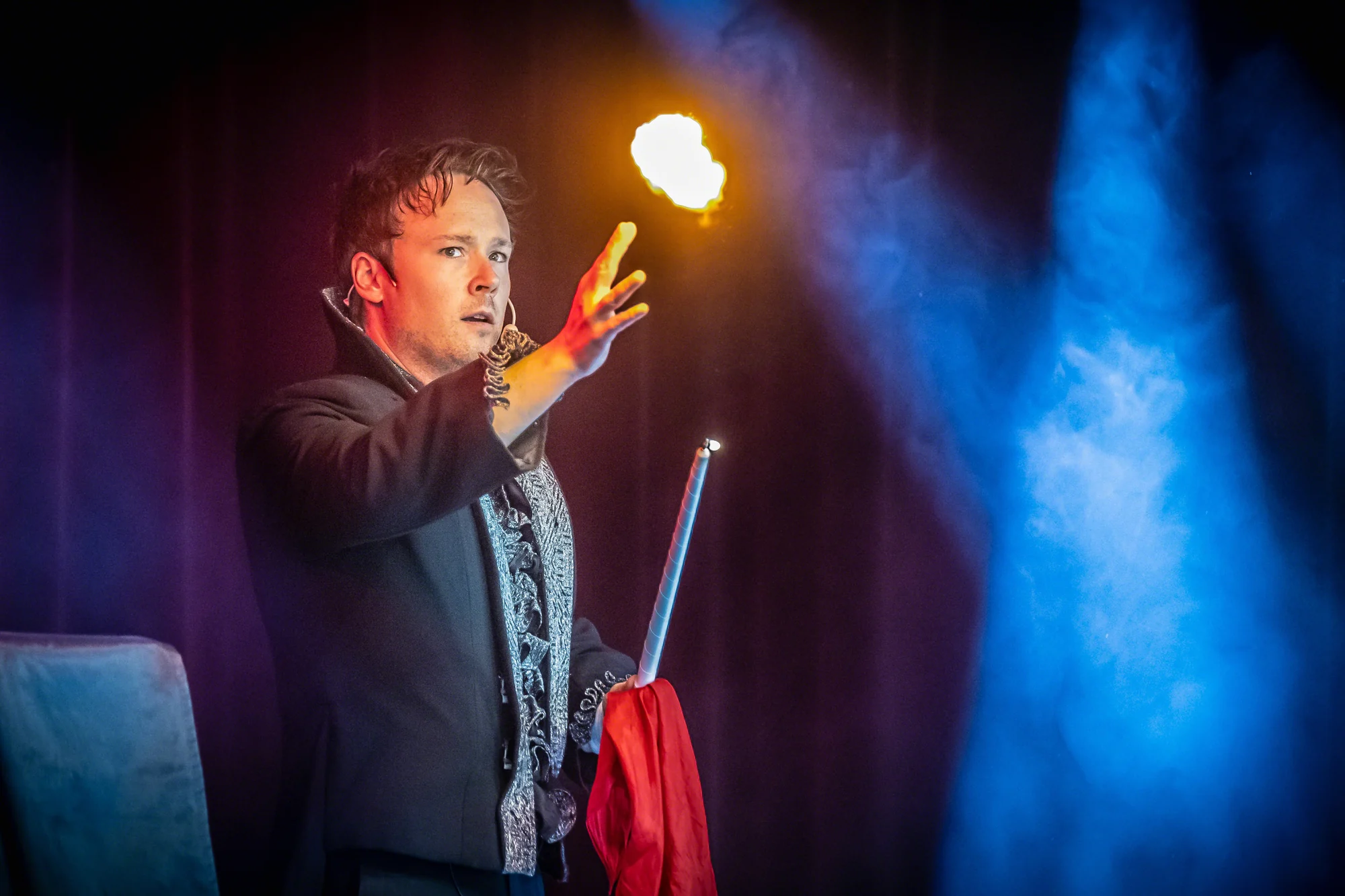 Magiker till jubileum, eld Magikern Daniel Kane med en eldboll ovanför handen på scen